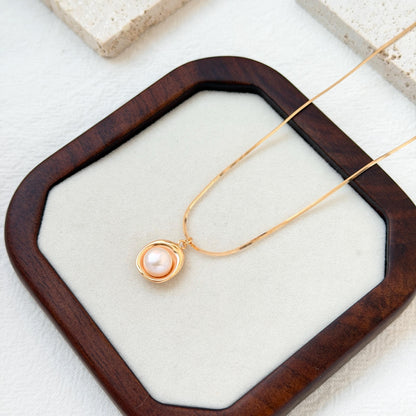 close up of 18k gold freshwater pearl pendant necklace delicate chain and pearl
