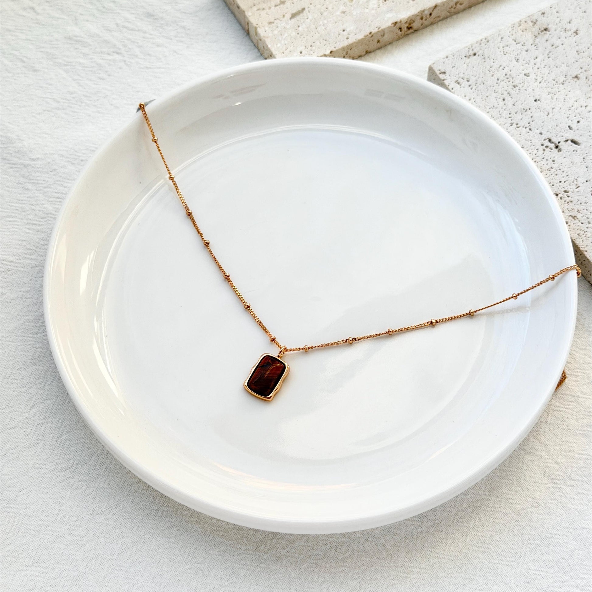 minimalist 18k gold tigers eye necklace styled flatlay jewelry
