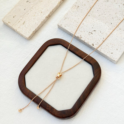 minimalist 18k gold knot tassel necklace styled flatlay jewelry
