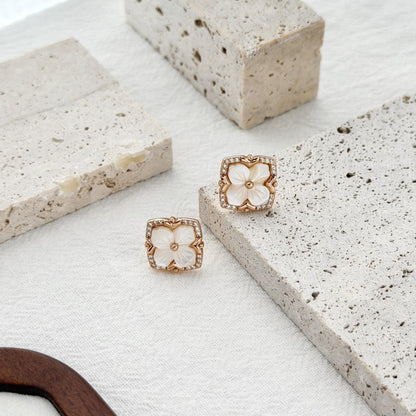 gold floral earrings with mother of pearl center and cubic zirconia border detail