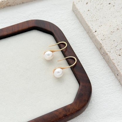 Elegant freshwater pearl earrings in curved gold setting with lightweight everyday design