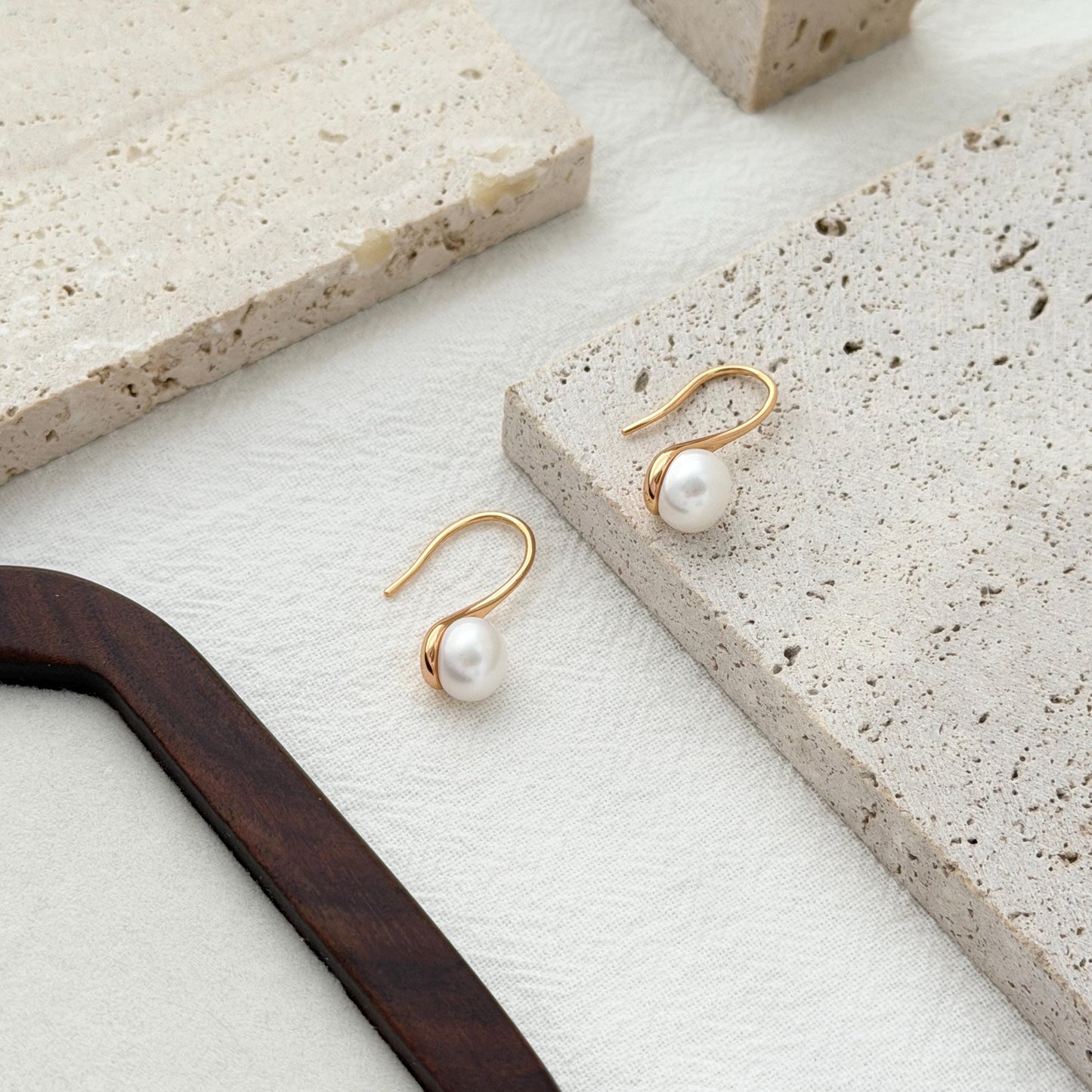 Modern pearl drop hook earrings with soft curved lines and timeless minimalist style