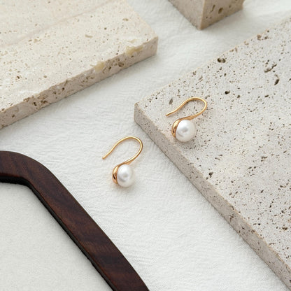 Modern pearl drop hook earrings with soft curved lines and timeless minimalist style