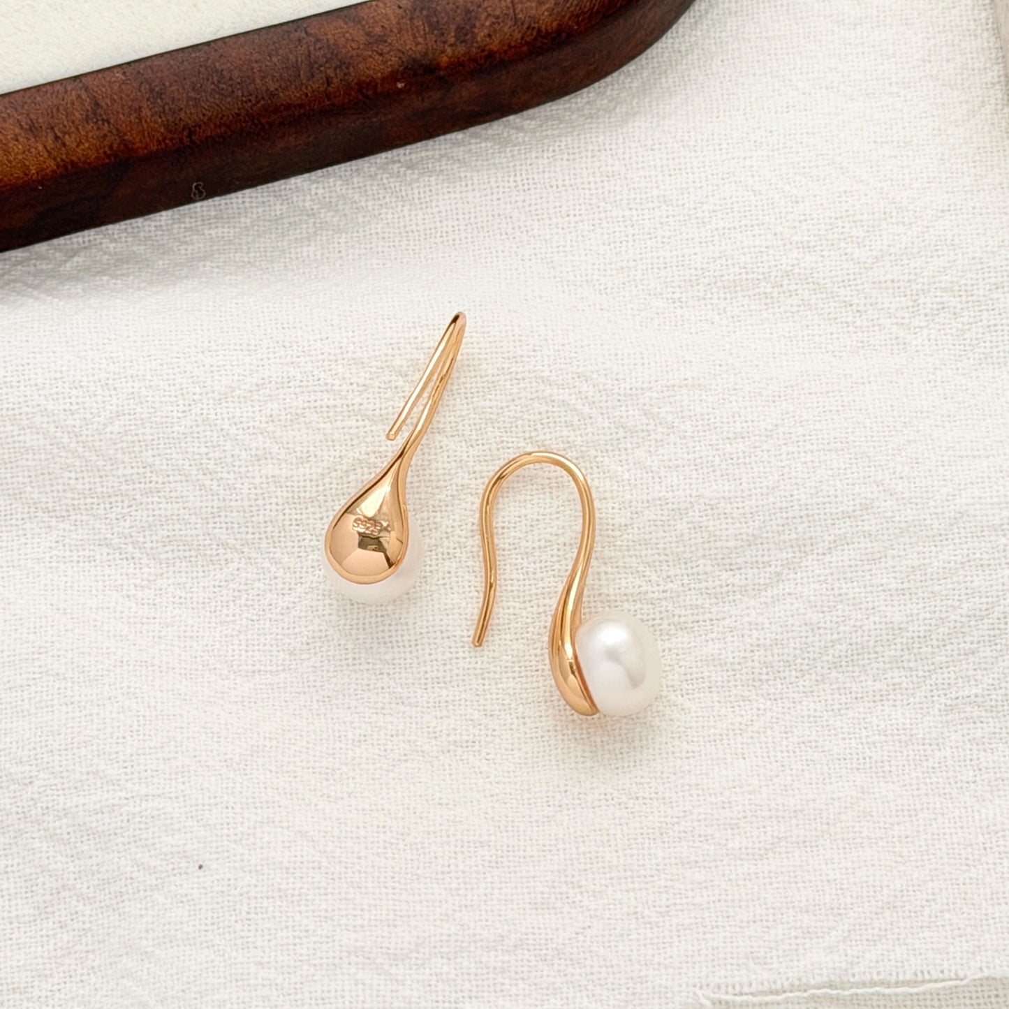 Curved gold pearl earrings with dainty modern design perfect for everyday and bridal wear 