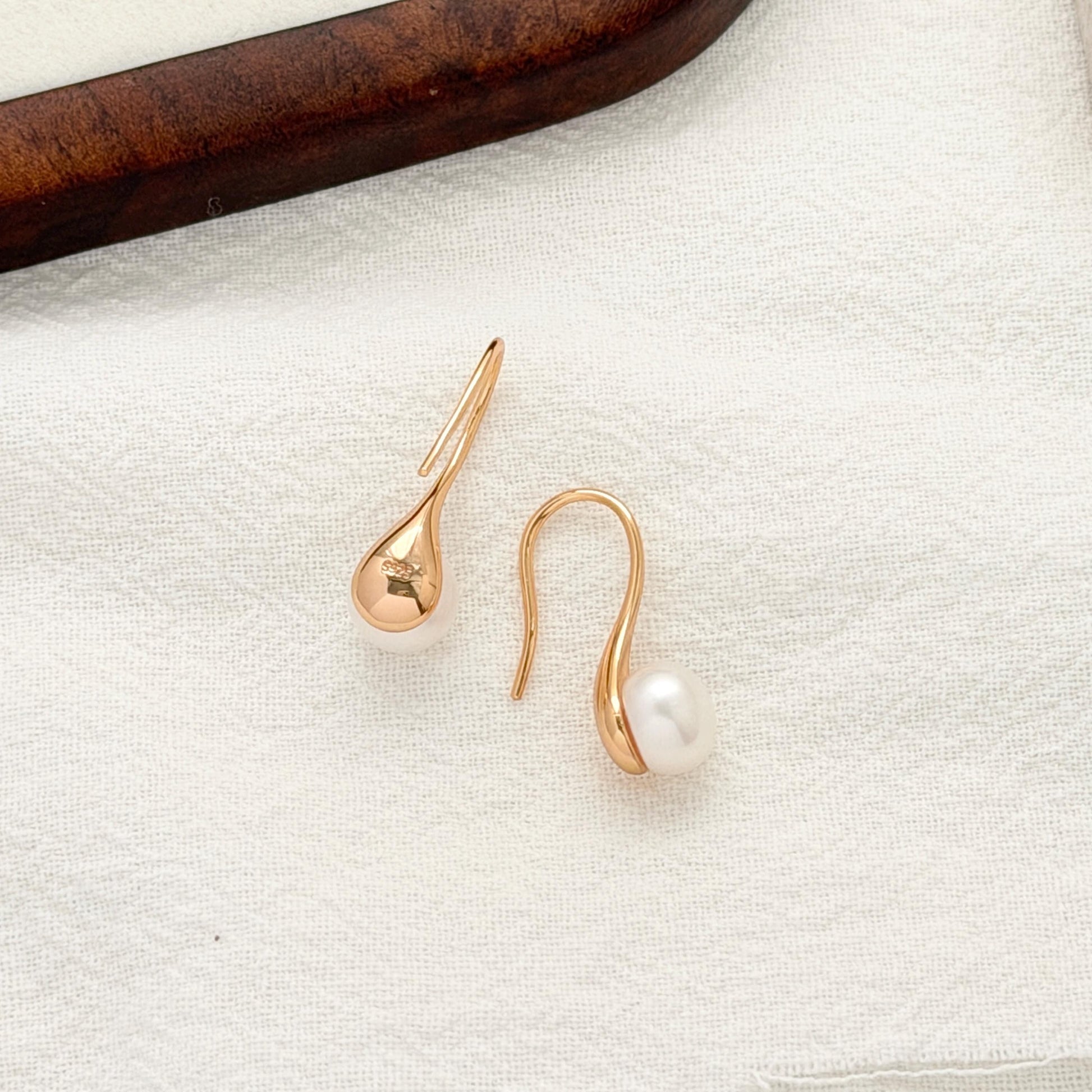 Curved gold pearl earrings with dainty modern design perfect for everyday and bridal wear 