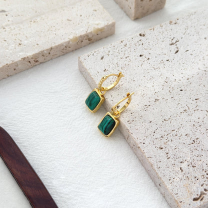 Small gold hoop earrings with deep green malachite charms and modern minimalist style