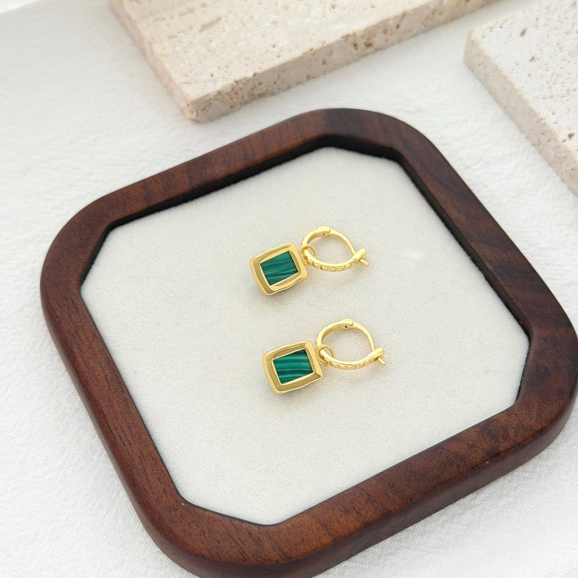 Gold hoop earrings with rich green malachite pendants and subtle statement silhouette