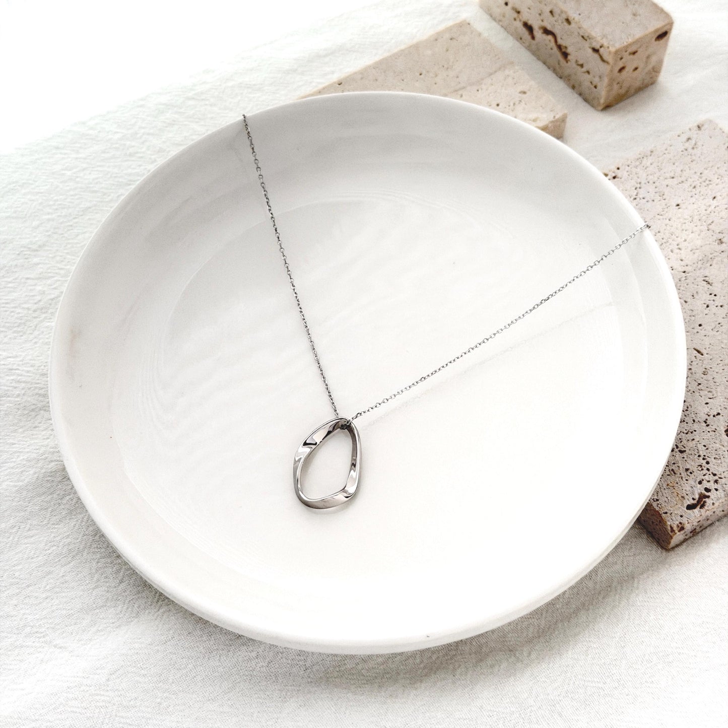 Modern statement necklace in sterling silver with fluid oval pendant silhouette