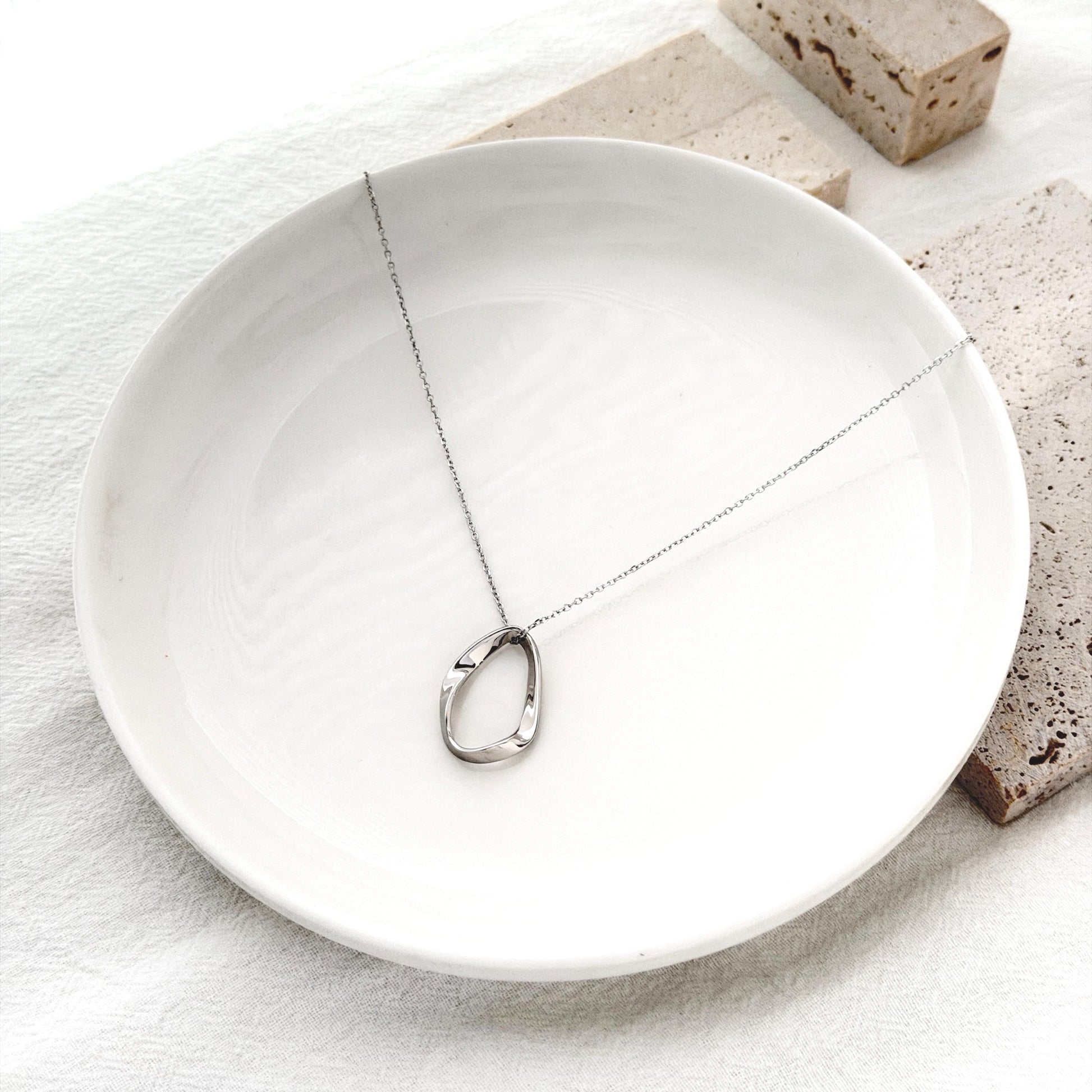 Modern statement necklace in sterling silver with fluid oval pendant silhouette