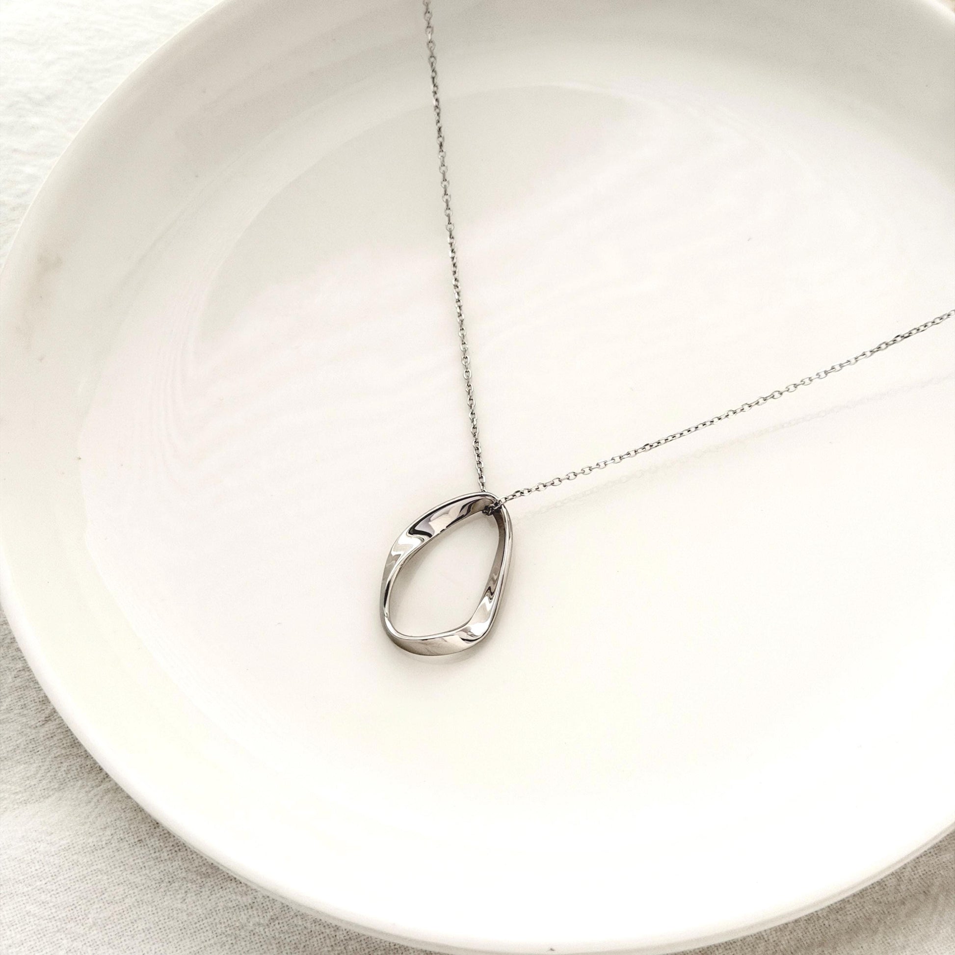 Organic silver necklace with modern oval pendant and elegant everyday styling 