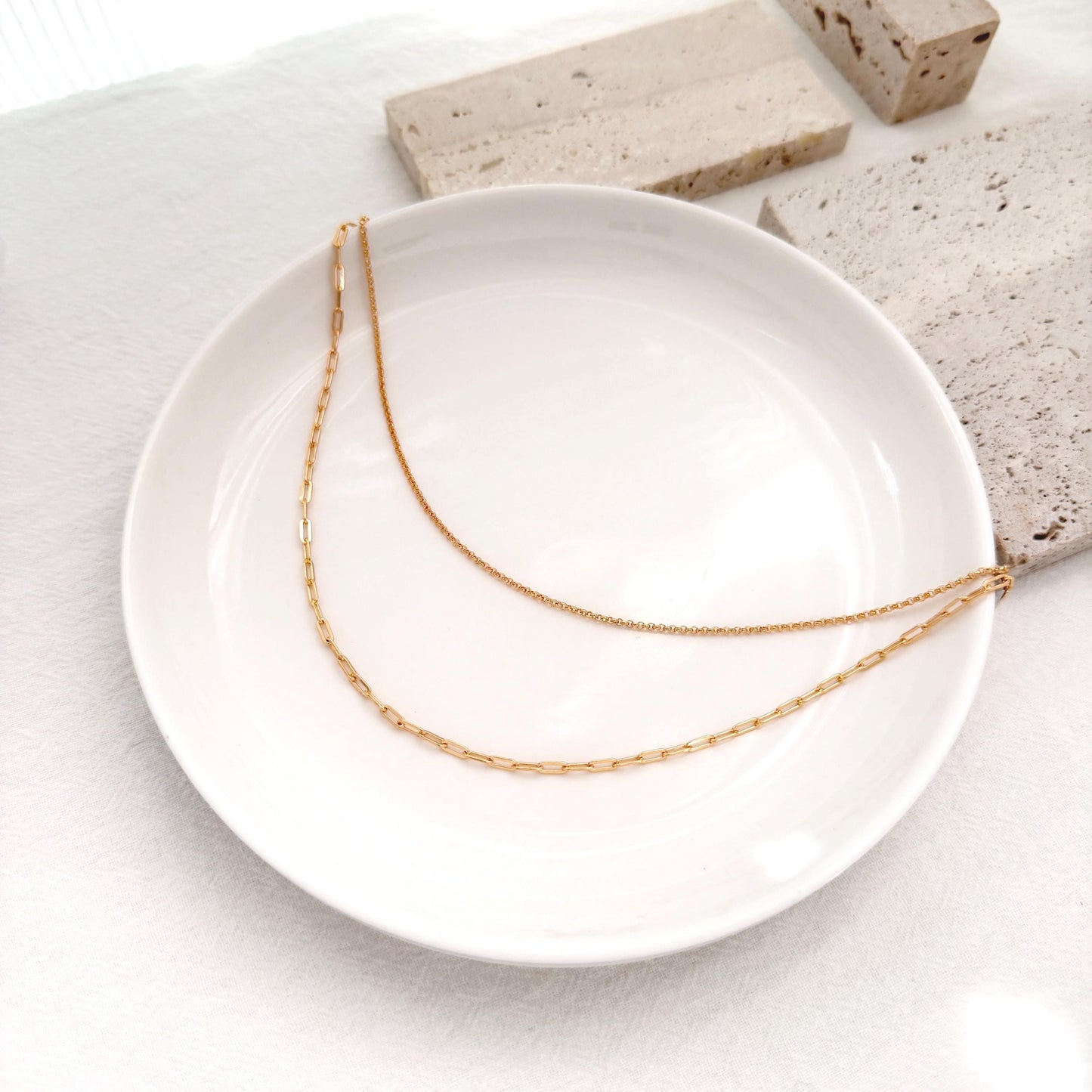 Minimal layered necklace in gold with paperclip chain and delicate double strand design