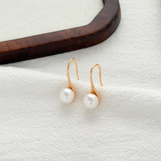 Dainty curved pearl earrings with freshwater pearls and elegant gold hook design in sterling silver