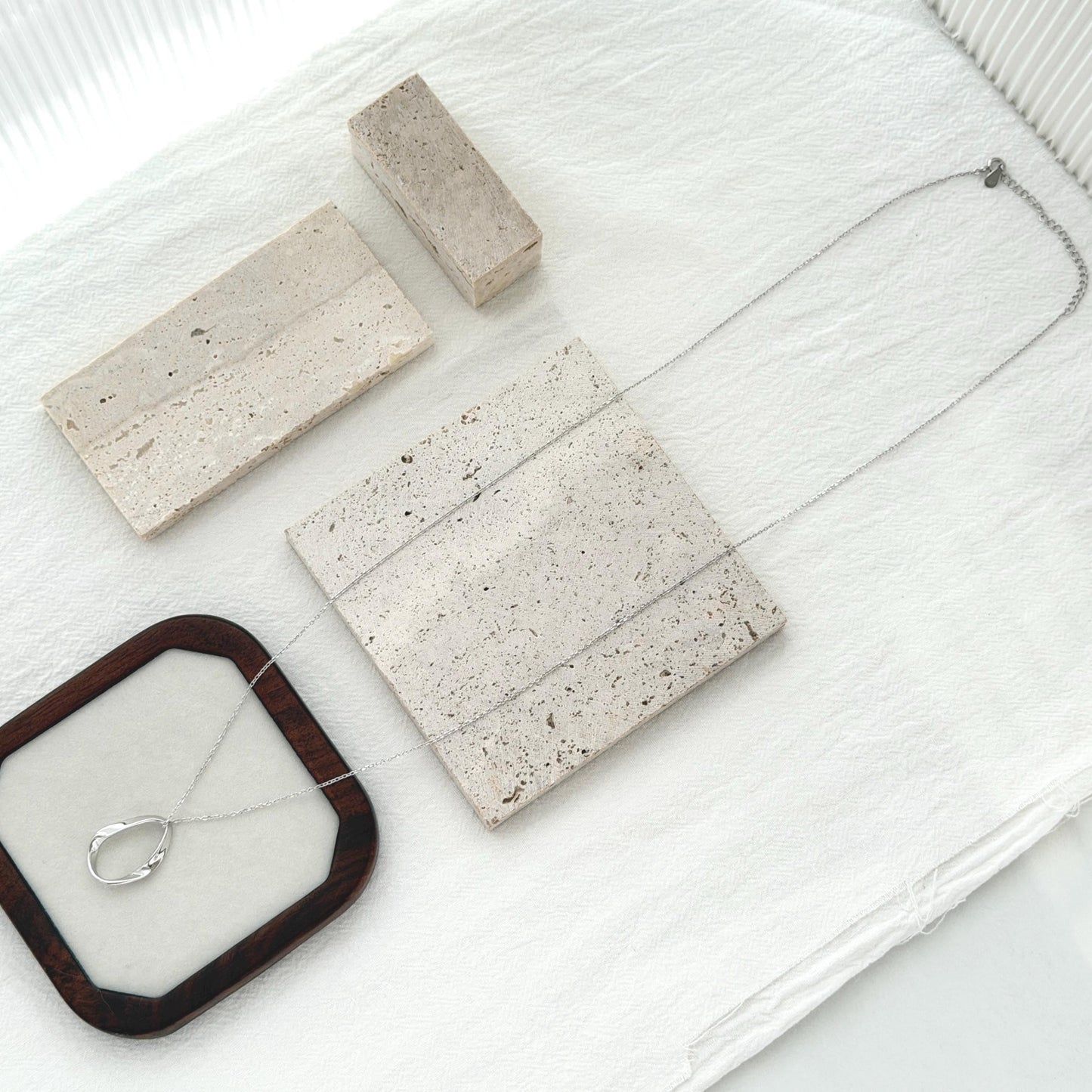 Minimal silver pendant necklace with elongated organic shape and delicate long chain