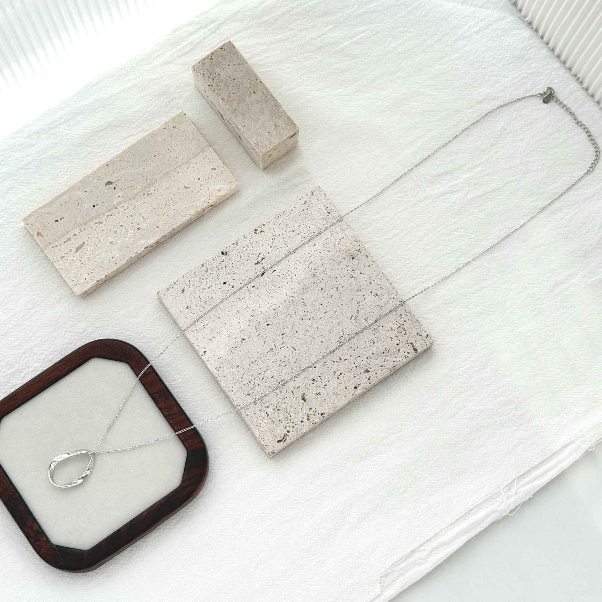 Minimal silver pendant necklace with elongated organic shape and delicate long chain