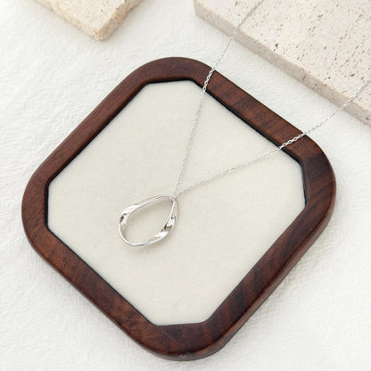 Long silver pendant necklace with organic oval pendant and minimalist modern design