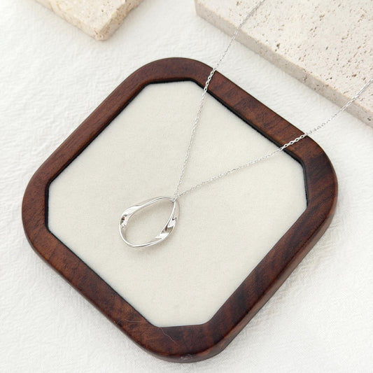 Long silver pendant necklace with organic oval pendant and minimalist modern design