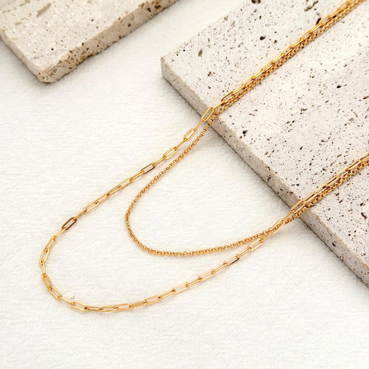 Layered gold necklace with double chain design and delicate paperclip chain details