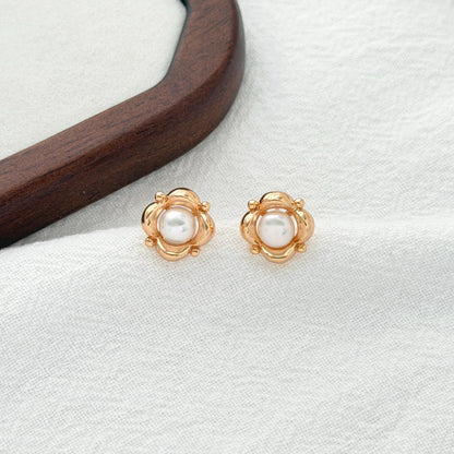 Sculptural floral pearl earrings in warm gold with round freshwater pearls and a vintage-inspired design.
