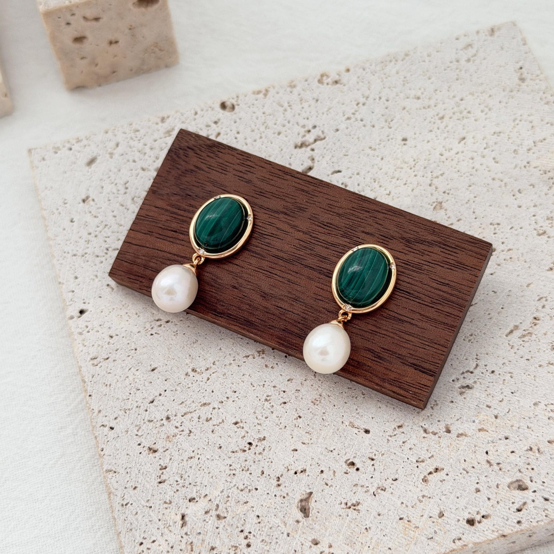 Malachite and freshwater pearl earrings styled with rich emerald green tones and gold details.