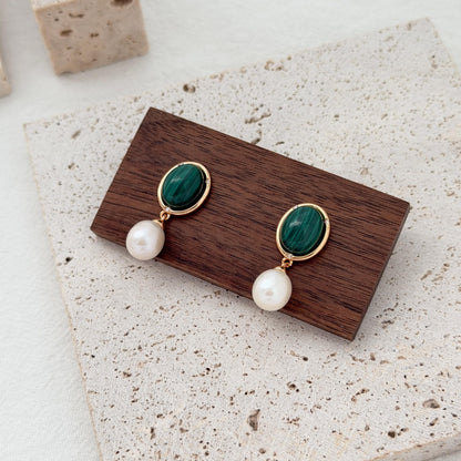 Malachite and freshwater pearl earrings styled with rich emerald green tones and gold details.