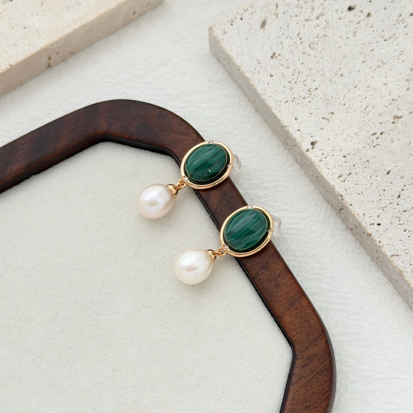 Elegant green pearl earrings with polished oval malachite stones in a vintage-inspired gold design.