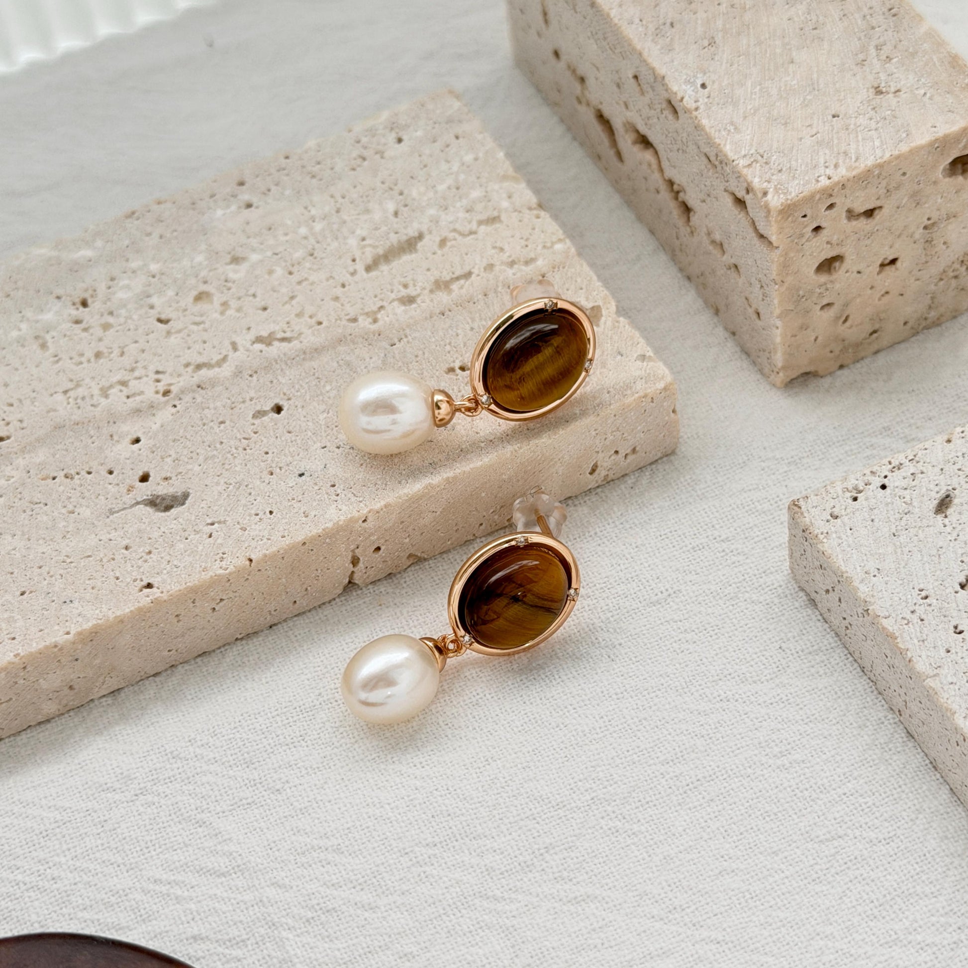 Gold tiger’s eye earrings with rich brown stones and luminous freshwater pearl drops.