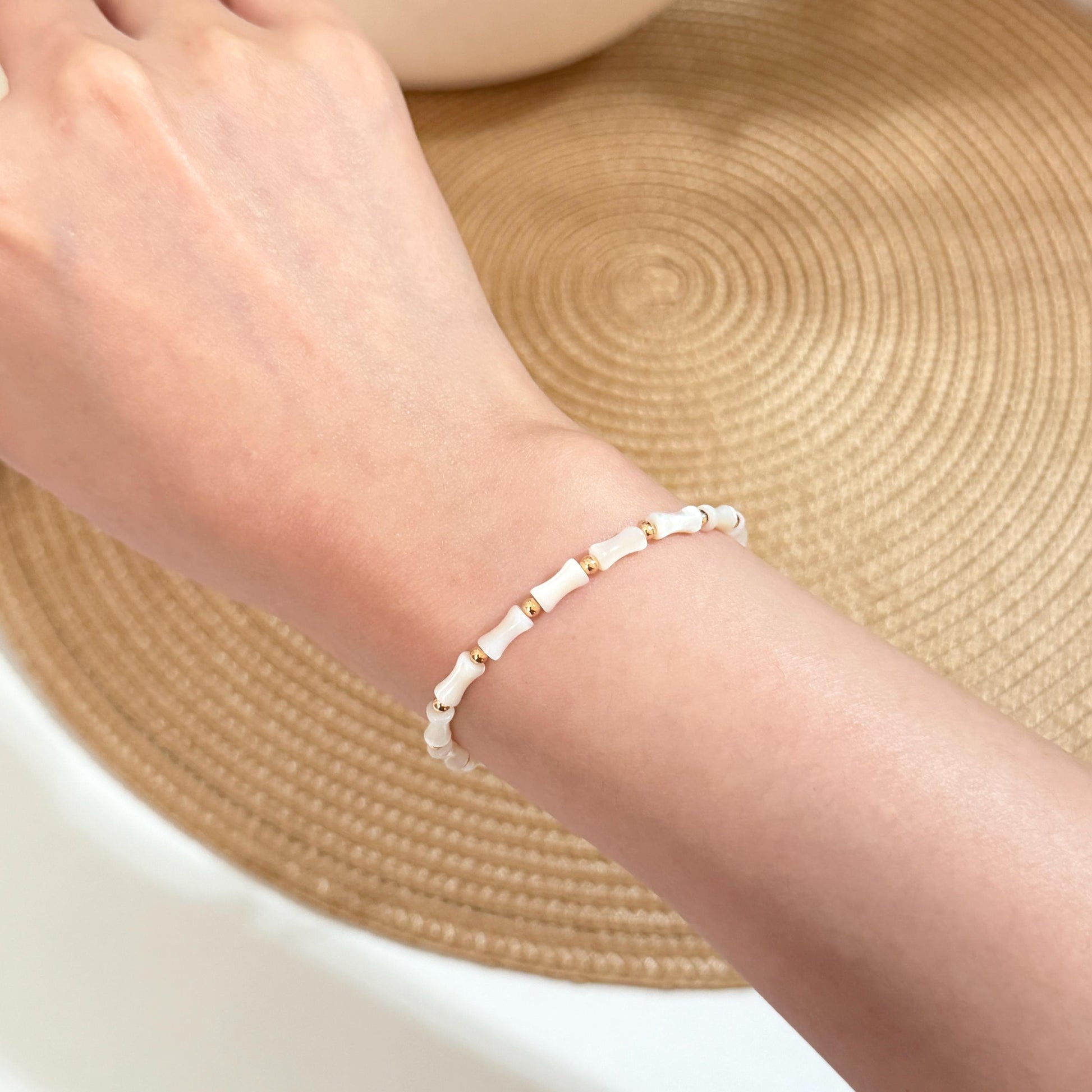 White shell wedding bracelet with polished gold bead details and adjustable fit.
