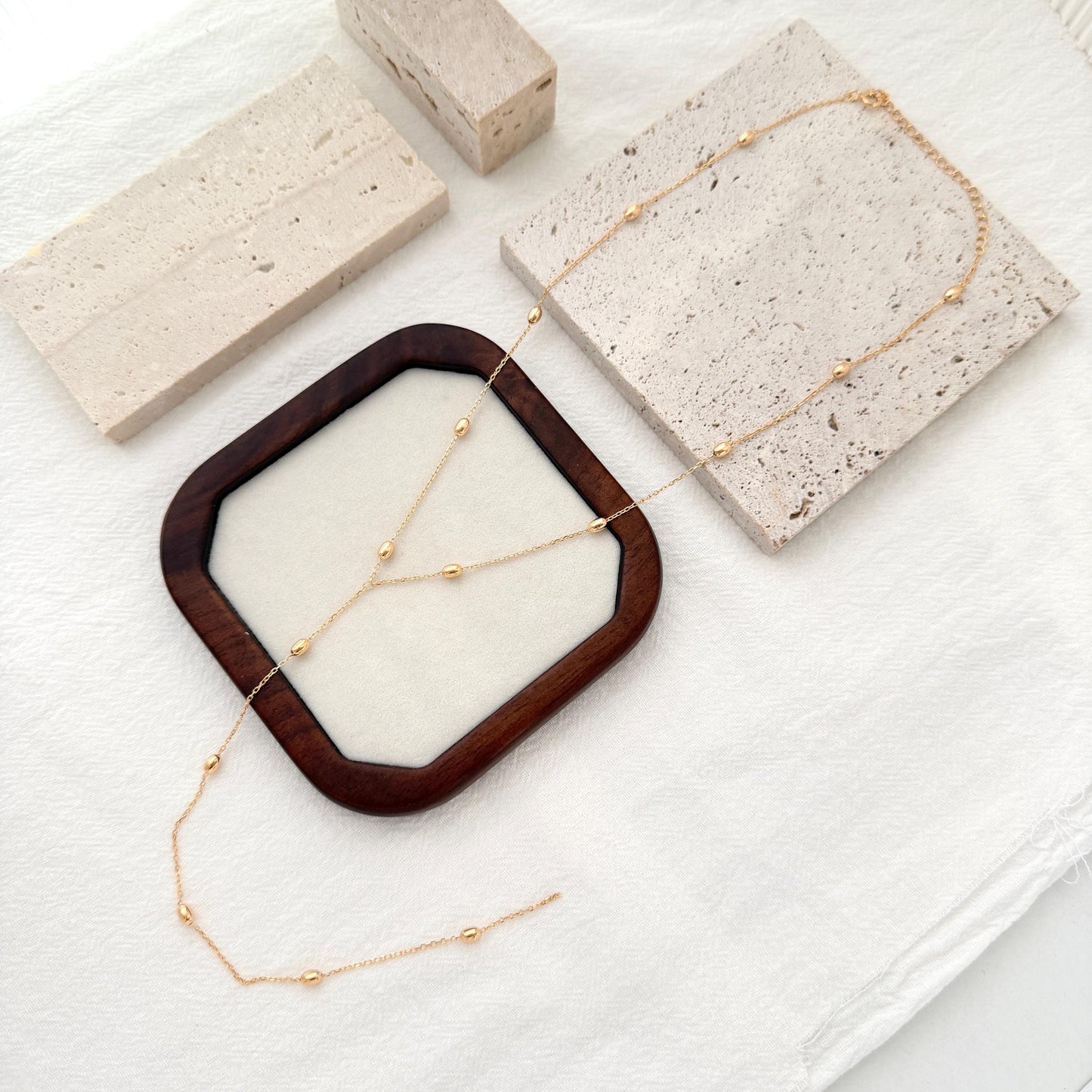Dainty gold Y necklace with small bead details and a delicate lariat-style drop.