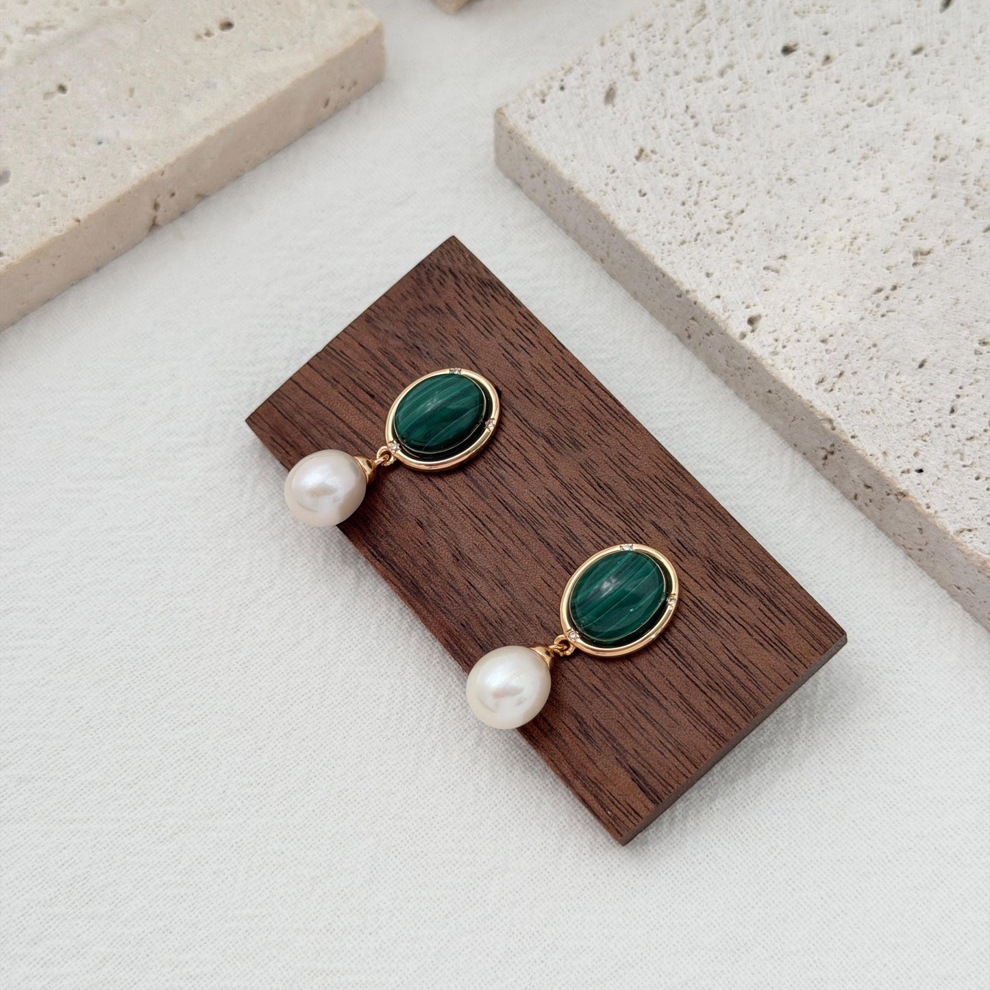 Green gemstone and pearl dangle earrings with oval malachite stones and delicate crystal accents.