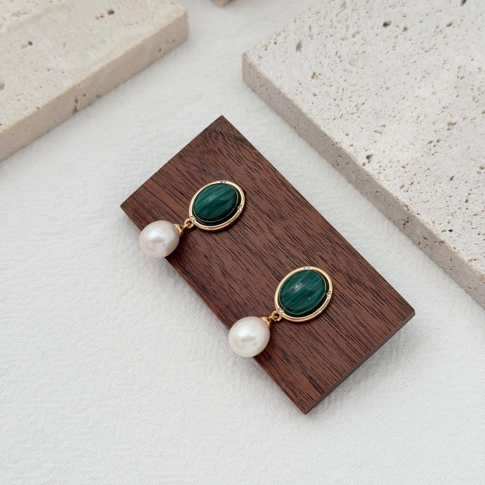 Green gemstone and pearl dangle earrings with oval malachite stones and delicate crystal accents.