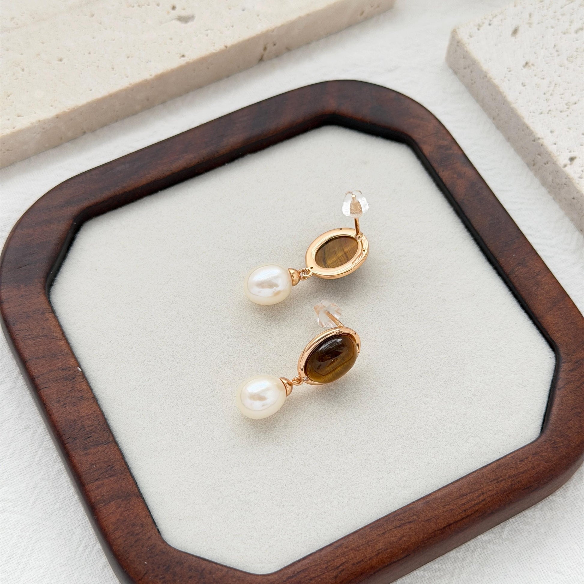 Brown bridal drop earrings with tiger’s eye gemstones, white pearls, and subtle crystal accents.