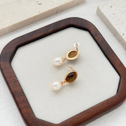 Brown bridal drop earrings with tiger’s eye gemstones, white pearls, and subtle crystal accents.