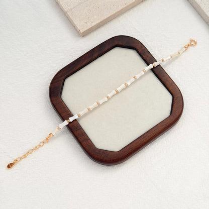 Ocean-inspired white shell bracelet with dainty gold beads and a delicate adjustable clasp