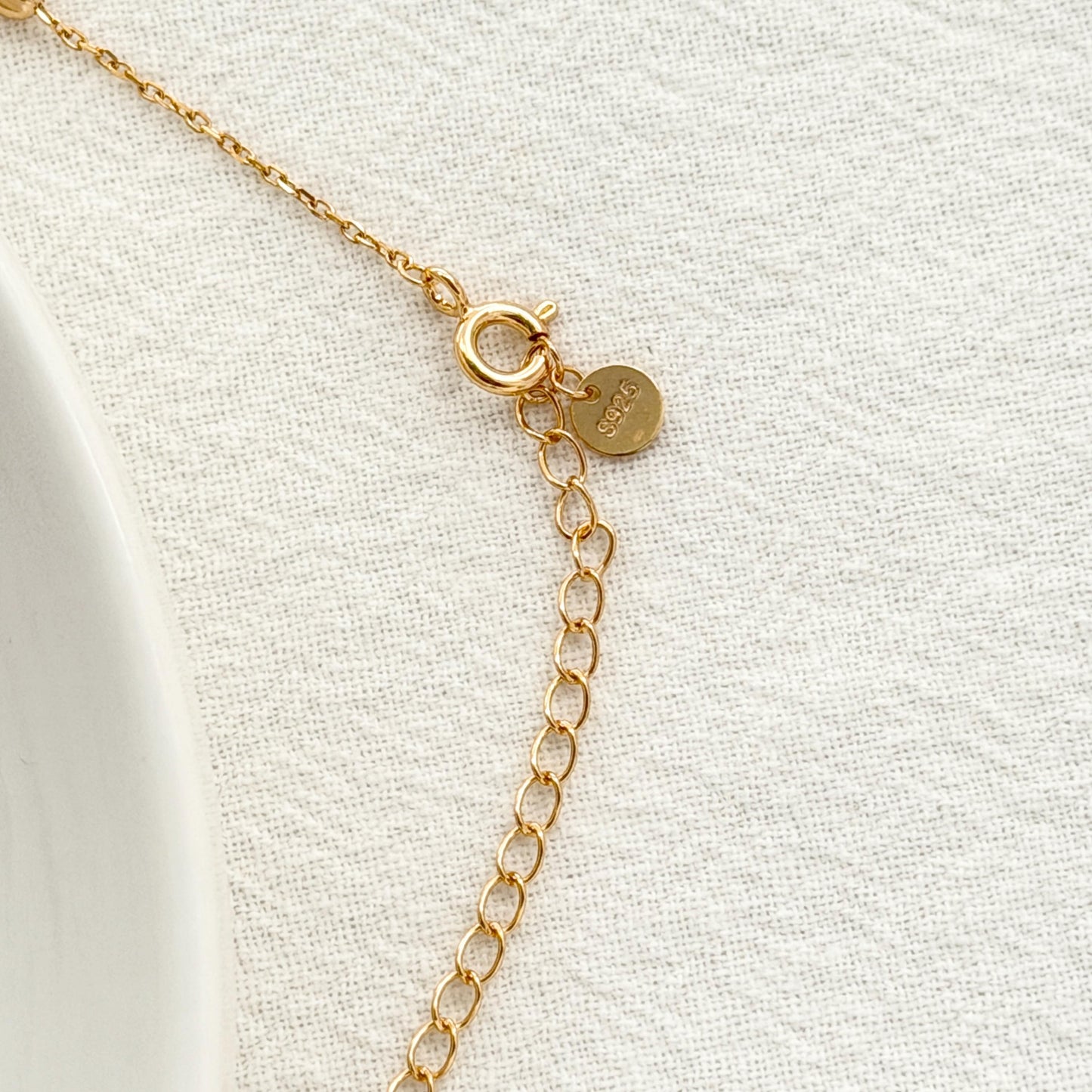 Delicate gold lariat necklace with subtle station beads and a soft minimalist design.