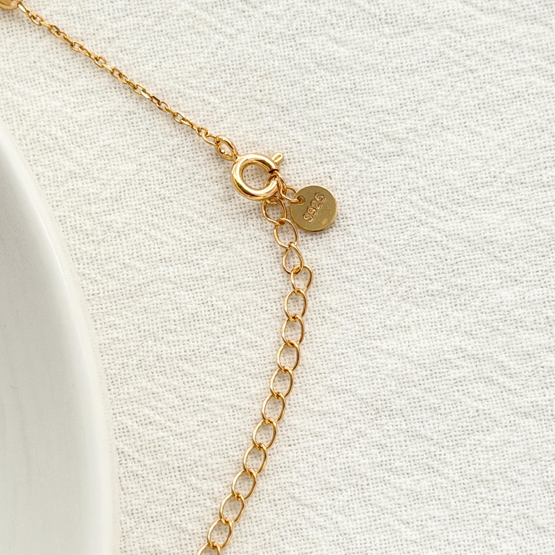 Delicate gold lariat necklace with subtle station beads and a soft minimalist design.